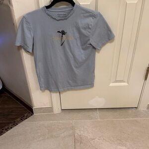 Calvin Klein Sky Blue Tee with Gold Logo with black flower. 100% cotton